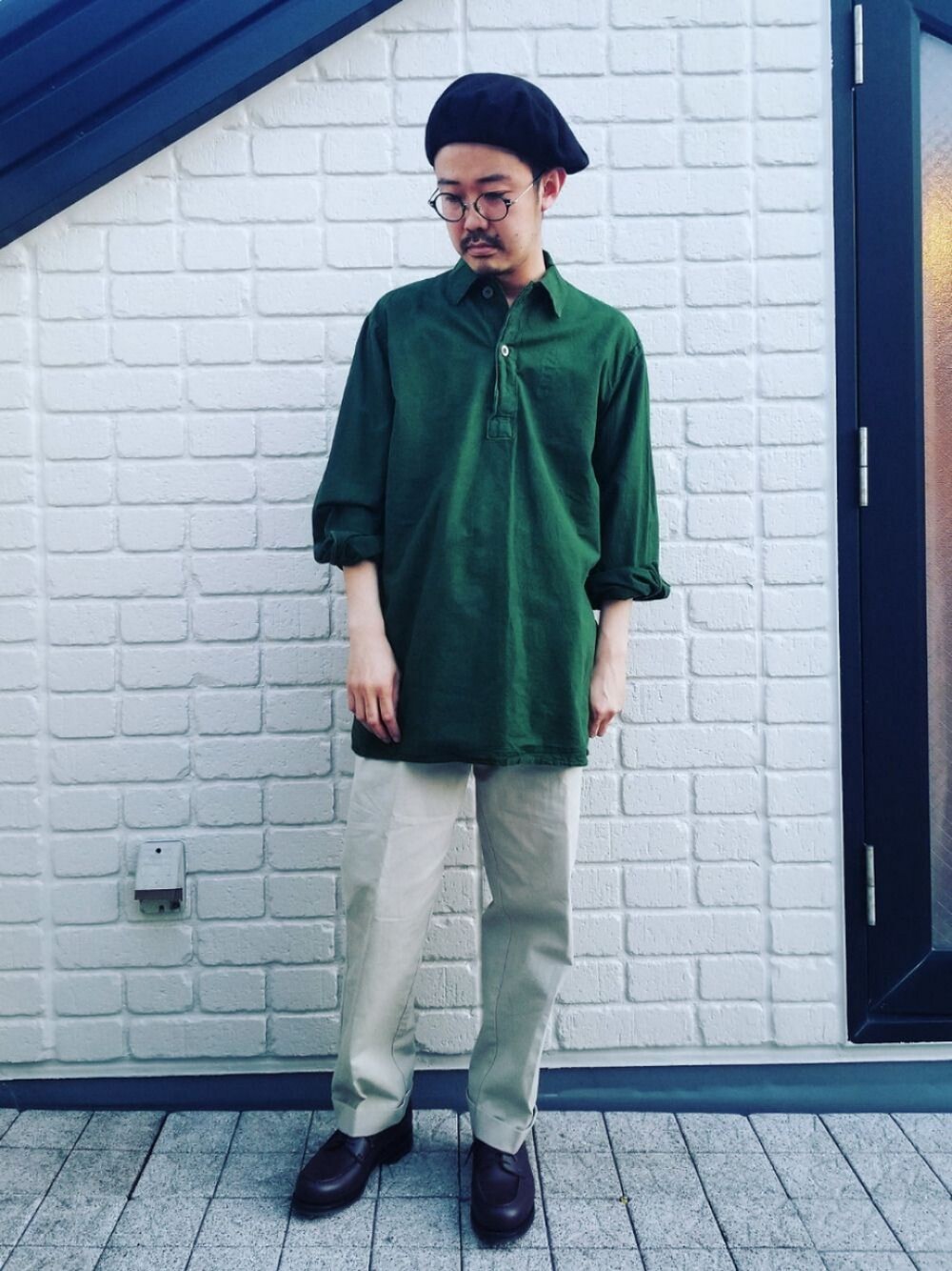 グリーン系のシャツ/ブラウス、ベージュ系のチノパンツ、ブラウン系のシューズを着用したメンズの春コーディネートの1枚目の写真