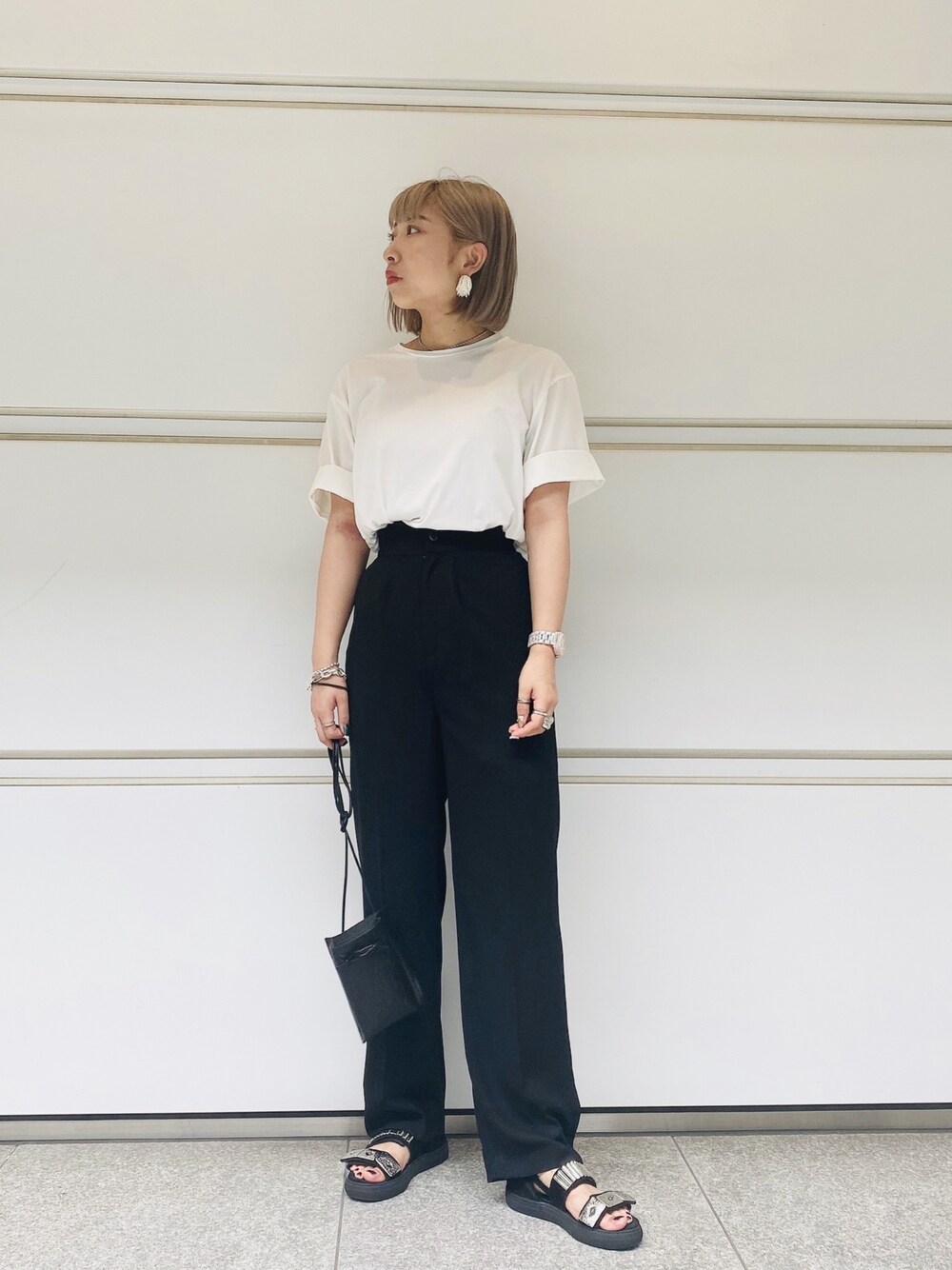 ブラック系のその他パンツ、ブラック系のサンダル、ホワイト系のTシャツ/カットソーを着用したレディースの夏コーディネートの1枚目の写真