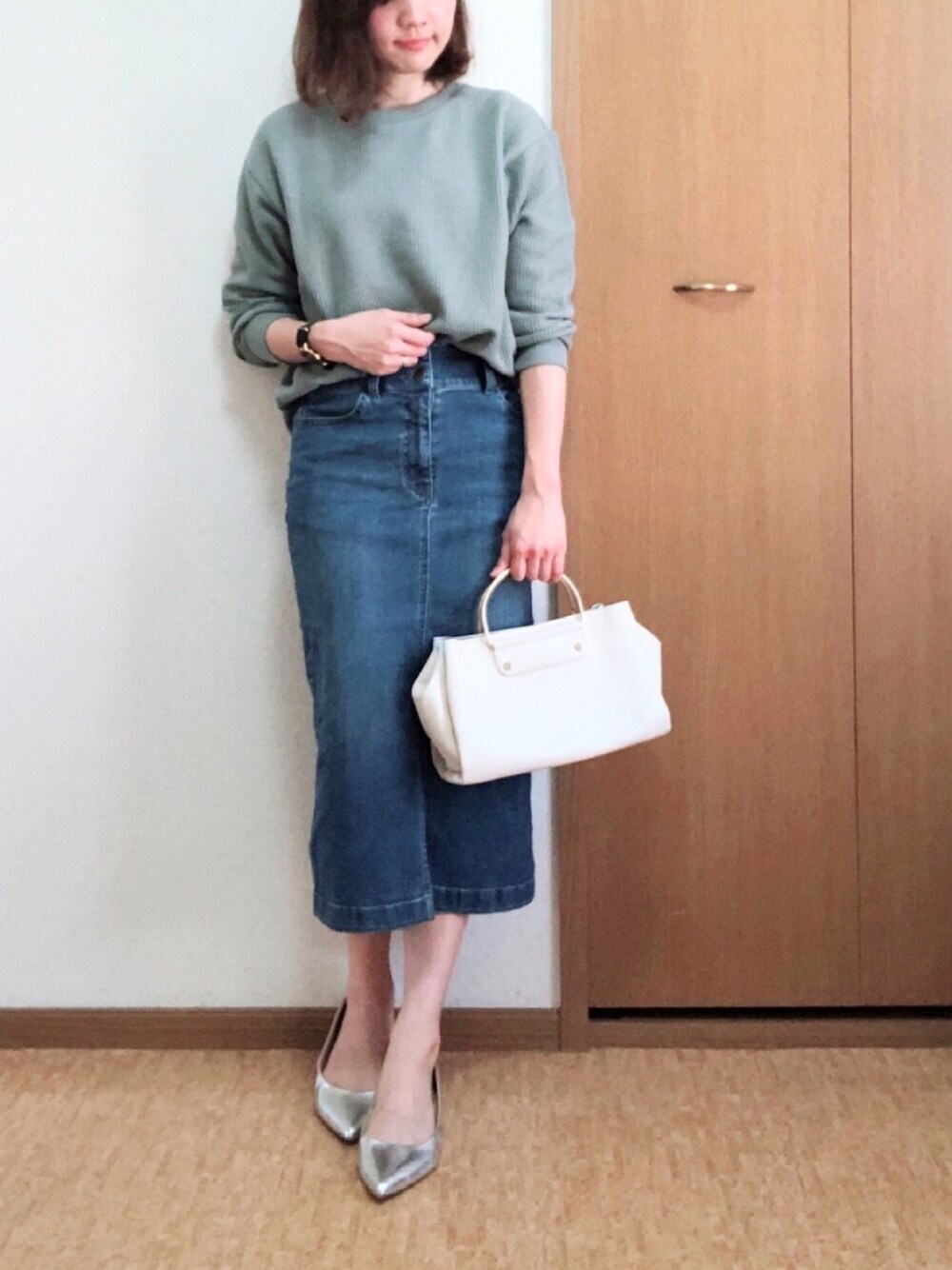 ブルー系のデニムスカート、グリーン系のTシャツ/カットソーを着用したレディースの春コーディネートの1枚目の写真
