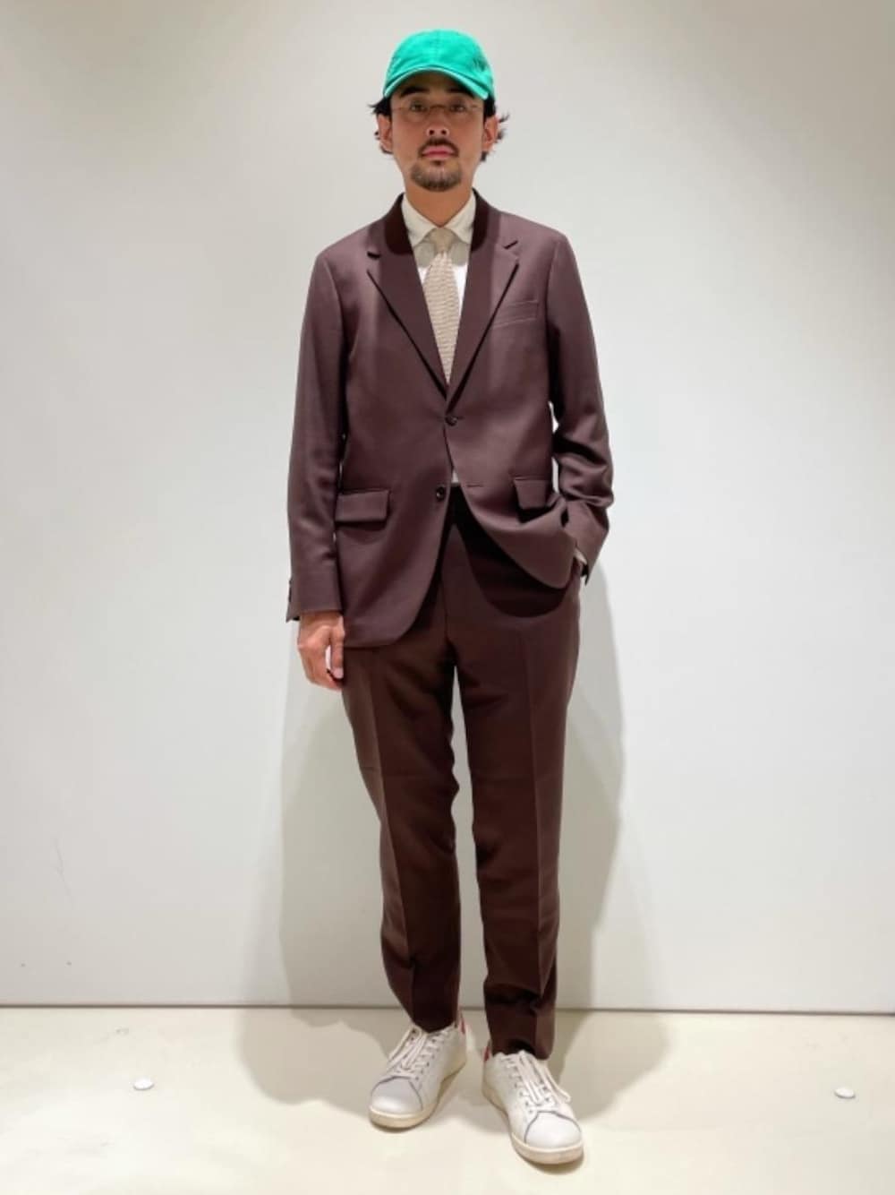 ブラウン系のテーラードジャケット、ブラウン系のその他パンツ、グリーン系のキャップを着用したメンズの夏コーディネートの1枚目の写真