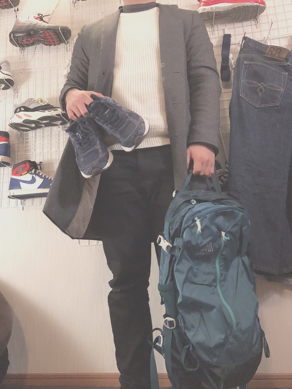ブラック系のデニムパンツ、グリーン系のバックパック/リュック、ブルー系のスニーカーを着用したメンズの冬コーディネートの1枚目の写真