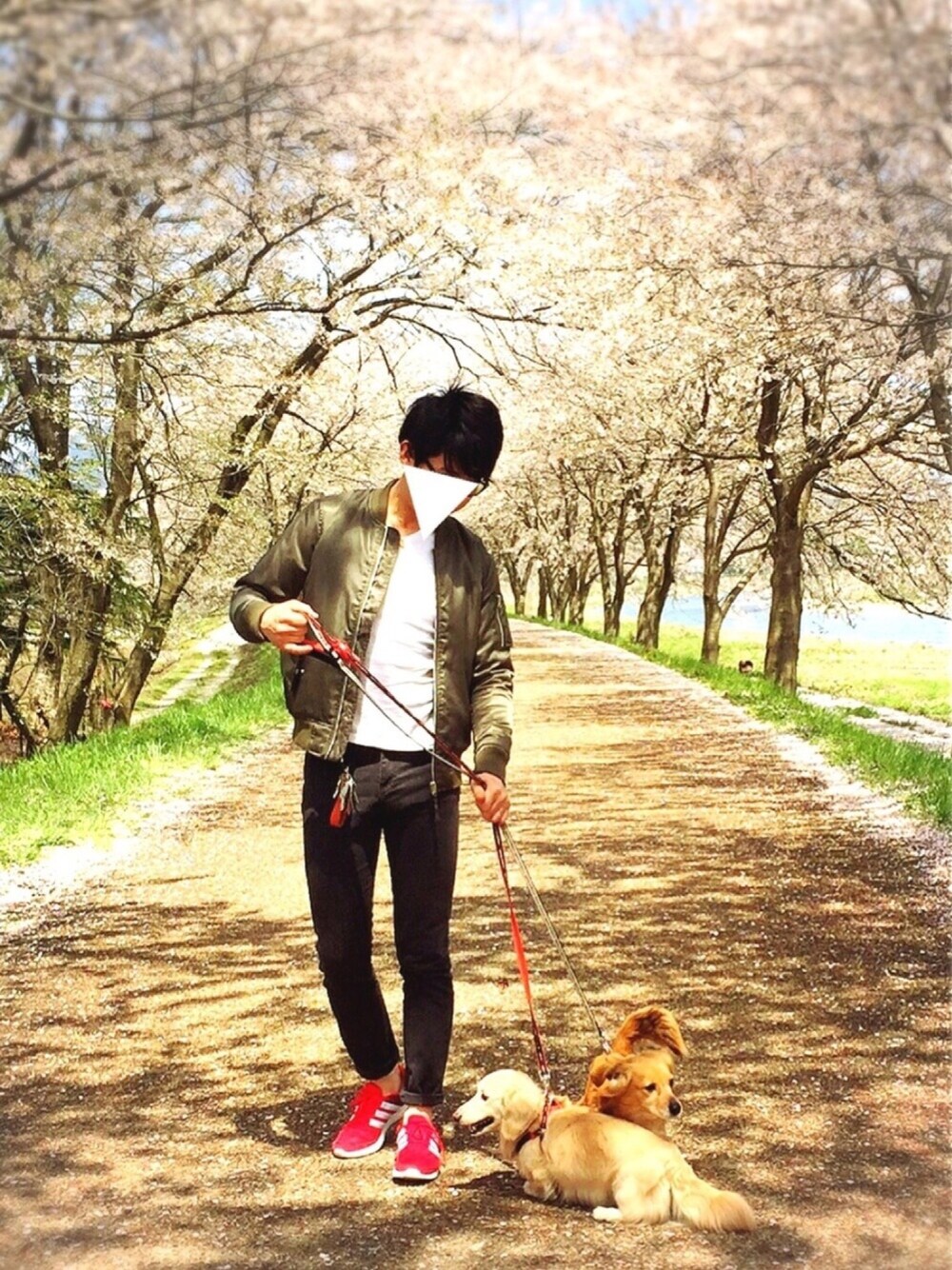 グリーン系のミリタリージャケット、ブラック系のチノパンツ、レッド系のスニーカーを着用したメンズの春コーディネートの1枚目の写真