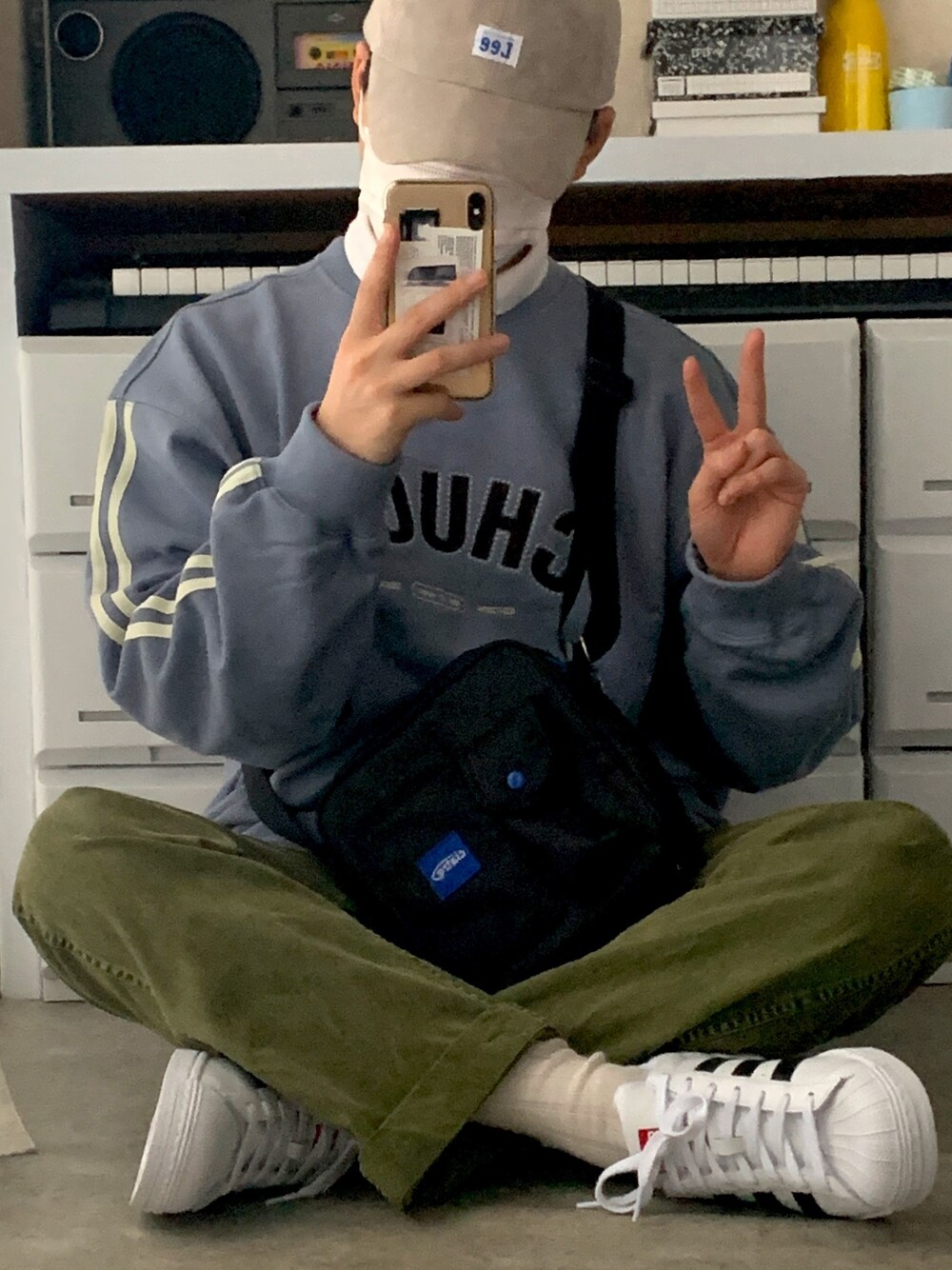 ブルー系のスウェット、グリーン系のチノパンツ、ホワイト系のスニーカーを着用したメンズの春コーディネートの1枚目の写真