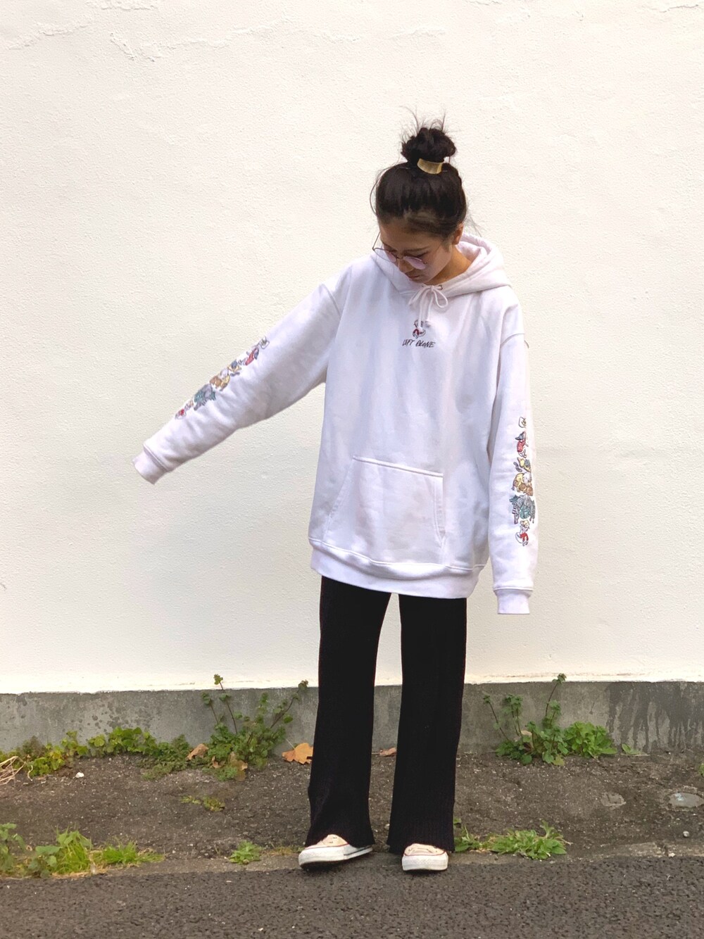 ホワイト系のパーカー、ブラック系のパンツ、ホワイト系のスニーカーを着用したレディースの冬コーディネートの1枚目の写真