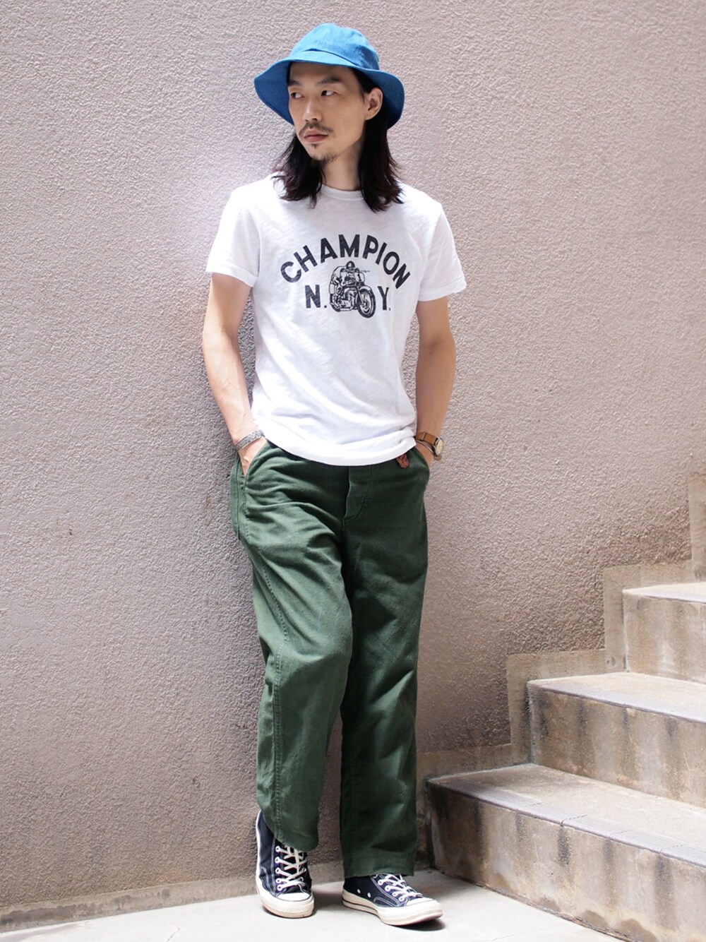 ホワイト系のTシャツ/カットソー、グリーン系のパンツ、ブラック系のスニーカーを着用したメンズの夏コーディネートの1枚目の写真