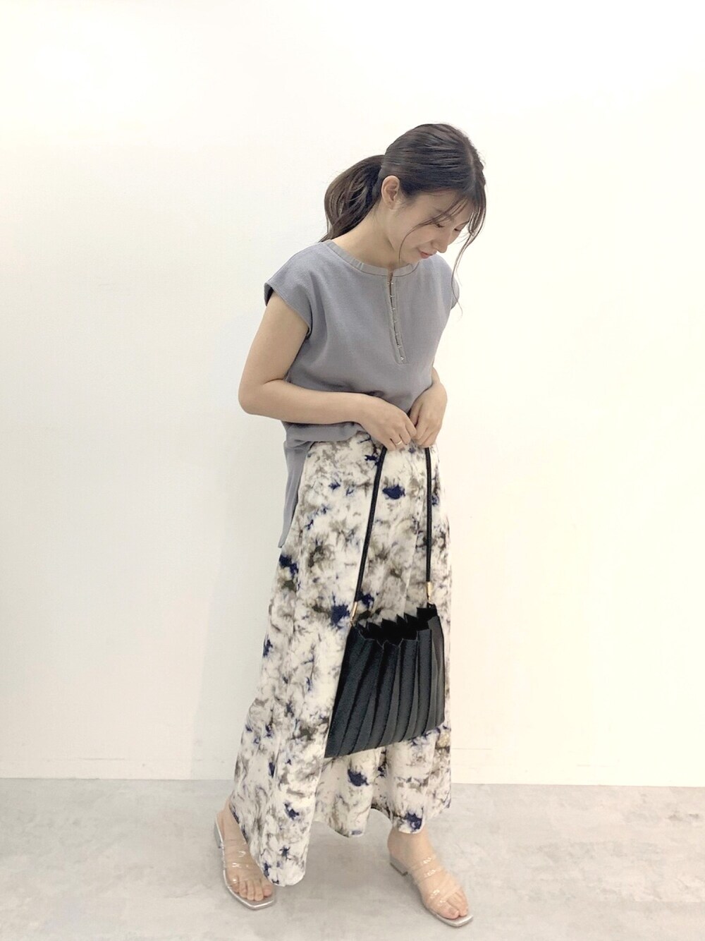 ブルー系のTシャツ/カットソー、ブルー系のスカート、ブラック系のショルダーバッグを着用したレディースの春コーディネートの1枚目の写真