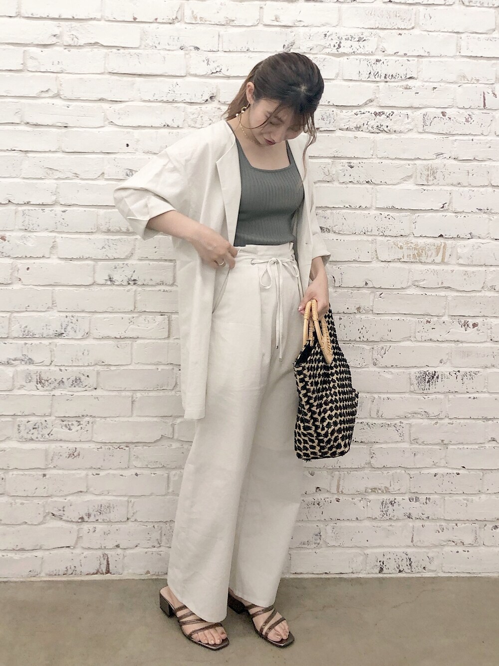 グリーン系のタンクトップ、ベージュ系のその他パンツ、ブラック系のサンダルを着用したレディースの夏コーディネートの1枚目の写真
