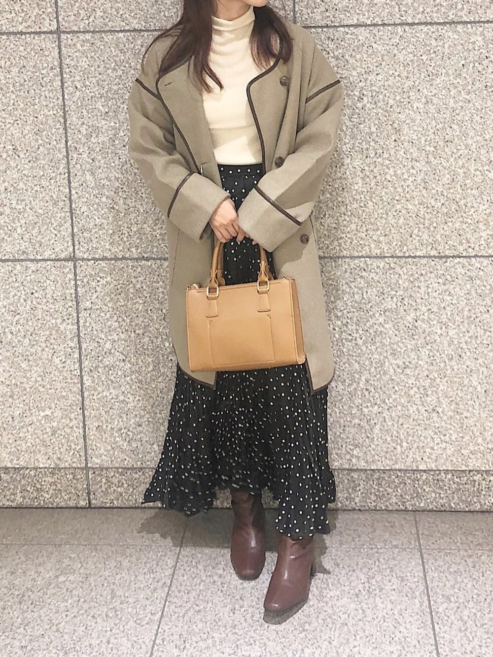 ホワイト系のニット/セーター、ブラック系のスカート、ブラウン系のブーツを着用したレディースの秋コーディネートの1枚目の写真