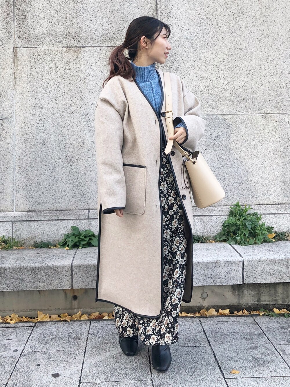 ブルー系のニット/セーター、ベージュ系のその他アウター、ブラック系のスカートを着用したレディースの秋コーディネートの1枚目の写真