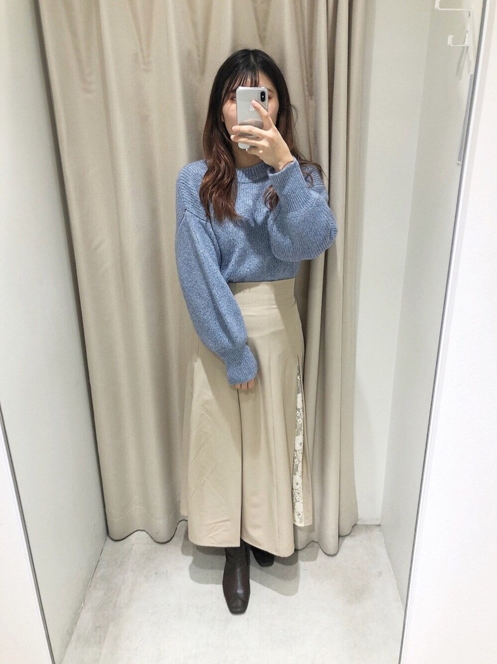 ブルー系のニット/セーター、ベージュ系のスカートを着用したレディースの冬コーディネートの1枚目の写真