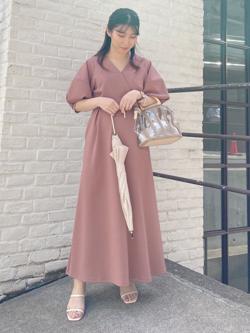レッド系のワンピース、ホワイト系のサンダル、ベージュ系のハンドバッグを着用したレディースの春コーディネートの1枚目の写真