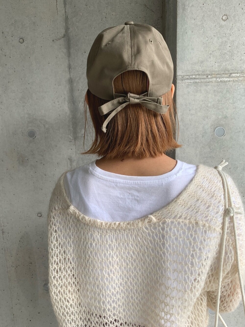 ベージュ系のキャップを着用したレディースの秋コーディネートの1枚目の写真