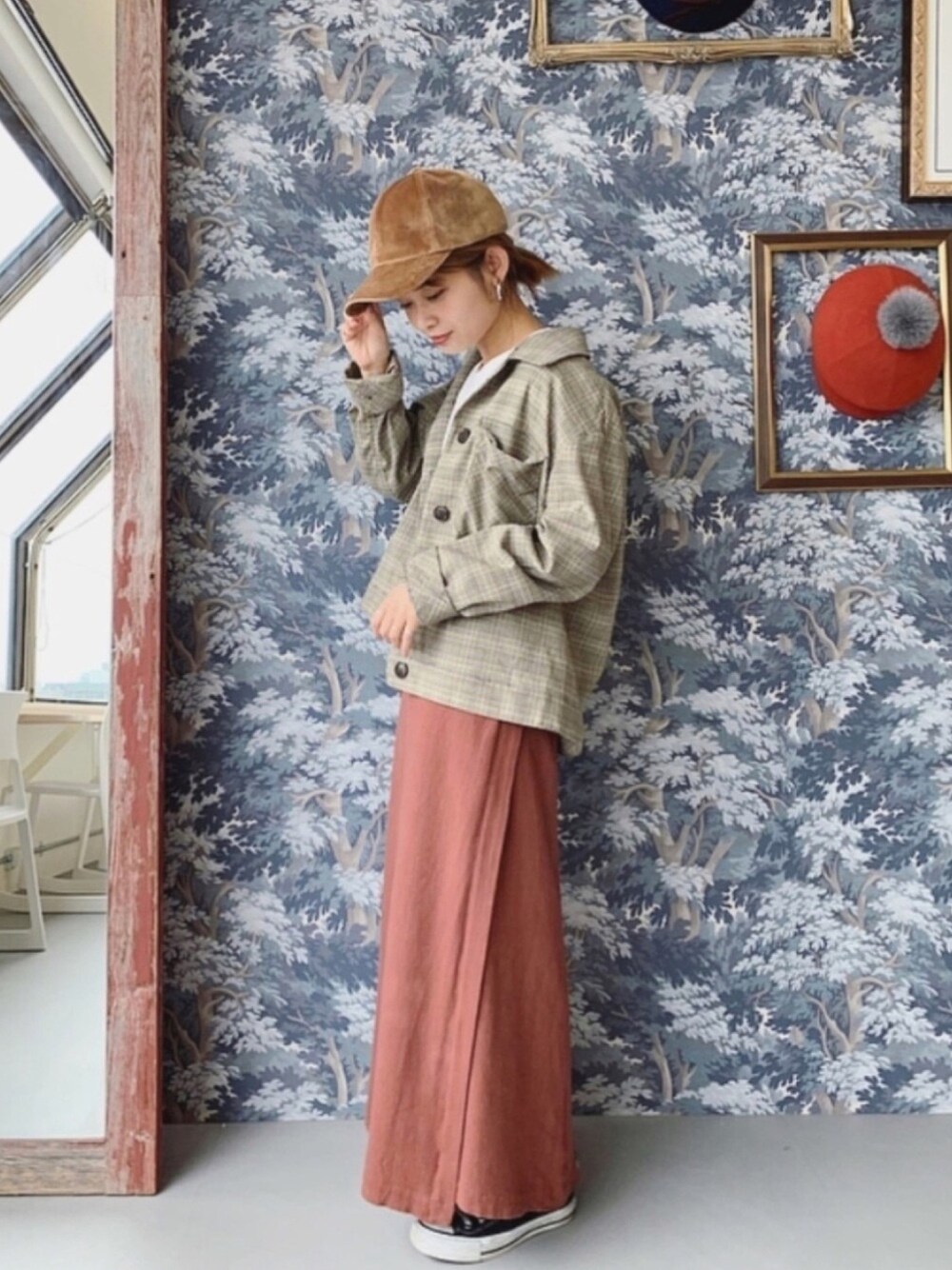 ブラウン系のスカート、ベージュ系のキャップを着用したレディースの秋コーディネートの1枚目の写真