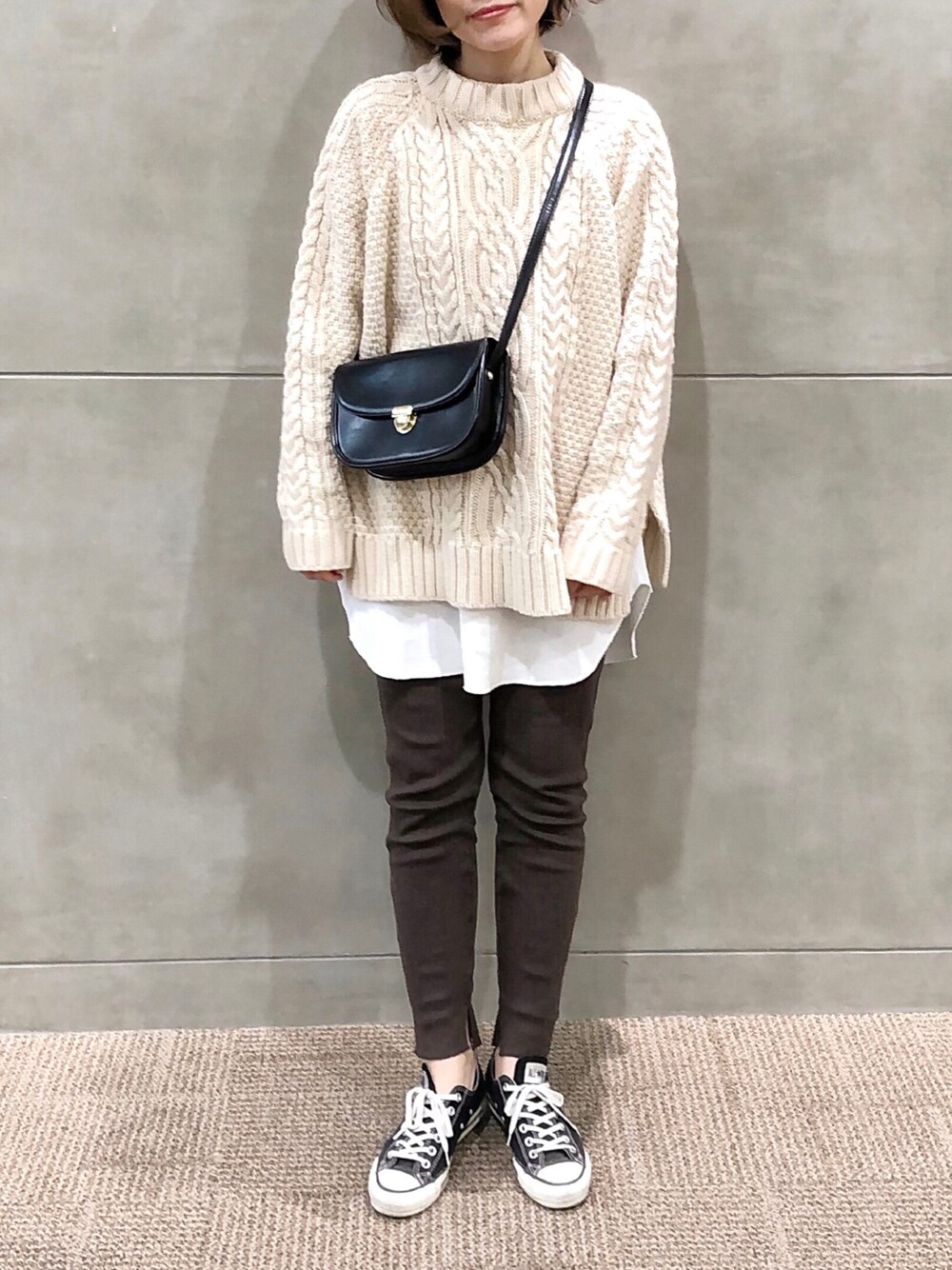 ホワイト系のニット/セーター、ホワイト系のワンピース、ブラック系のスニーカーを着用したレディースの冬コーディネートの1枚目の写真