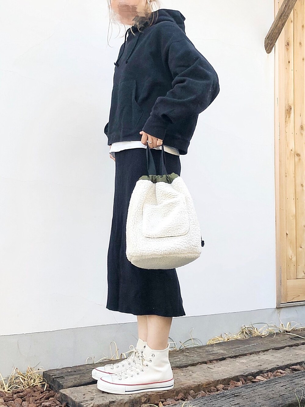 ブラック系のパーカー、ブラック系のスカート、ホワイト系のスニーカーを着用したレディースの秋コーディネートの1枚目の写真