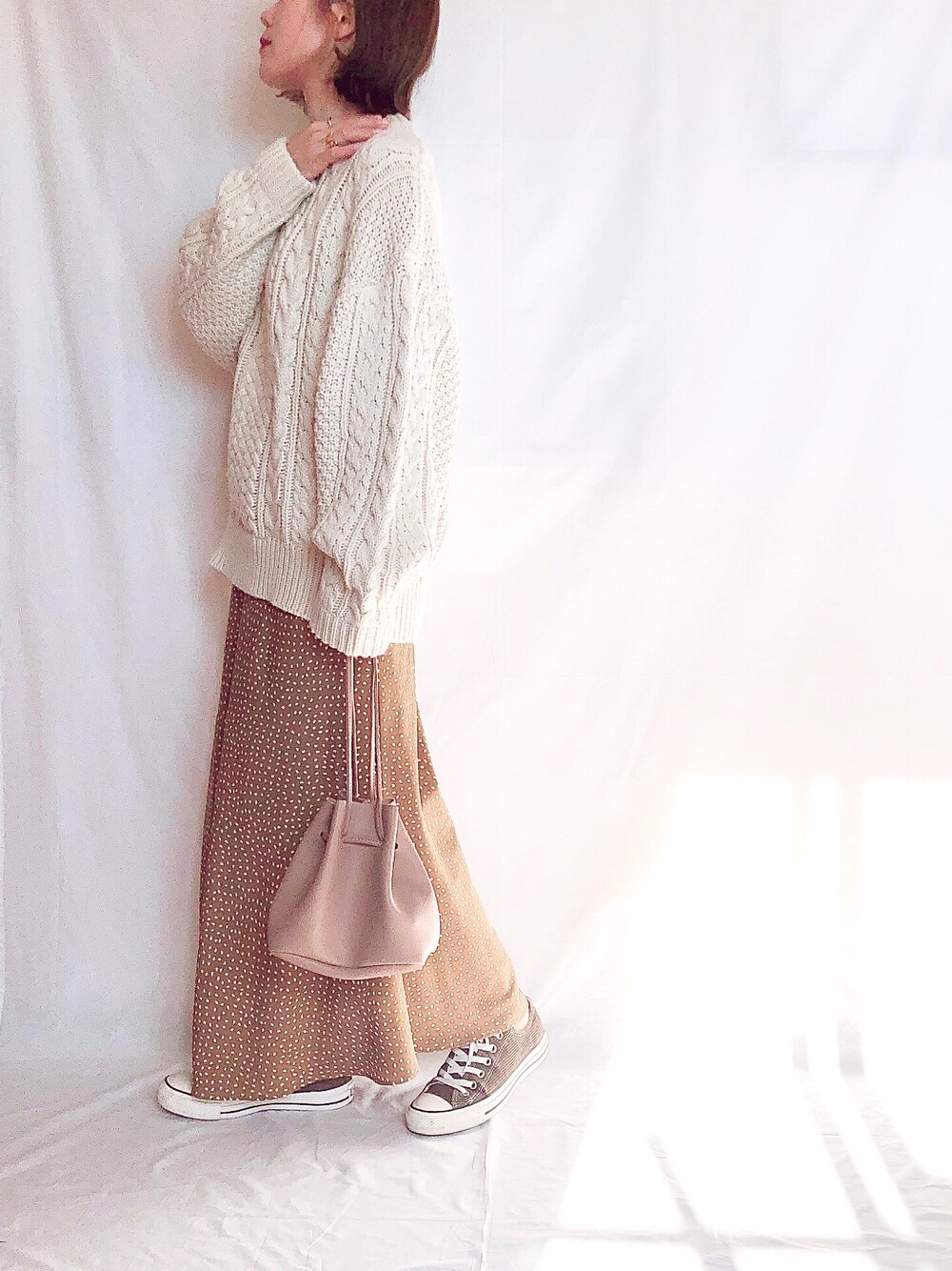 ホワイト系のニット/セーター、イエロー系のスカート、ブラウン系のスニーカーを着用したレディースの秋コーディネートの1枚目の写真