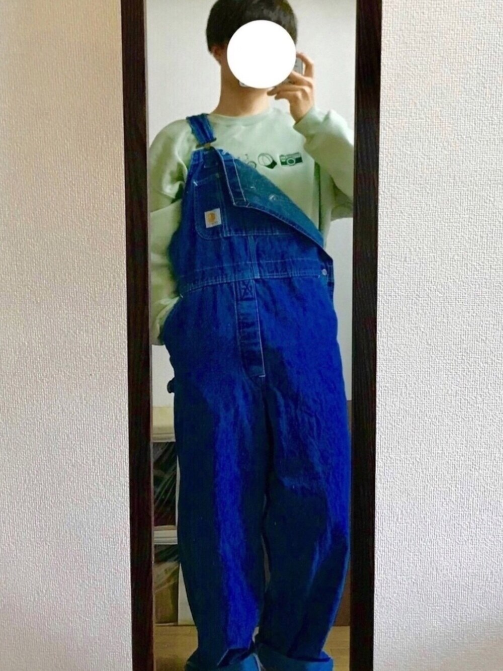 ブルー系のサロペット/オーバーオール、グリーン系のスウェットを着用したメンズの冬コーディネートの1枚目の写真