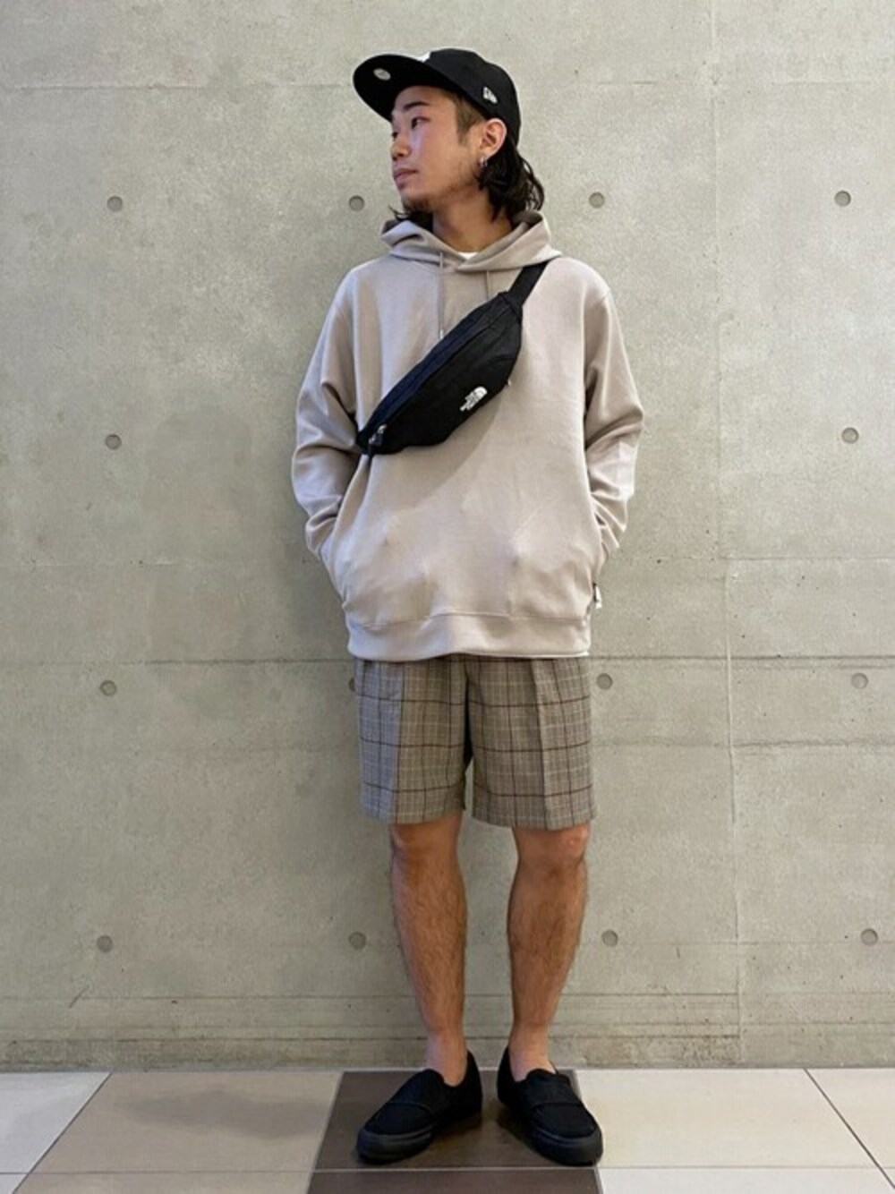 グレー系のパーカー、ブラック系のスニーカー、ベージュ系のその他パンツを着用したメンズの秋コーディネートの1枚目の写真