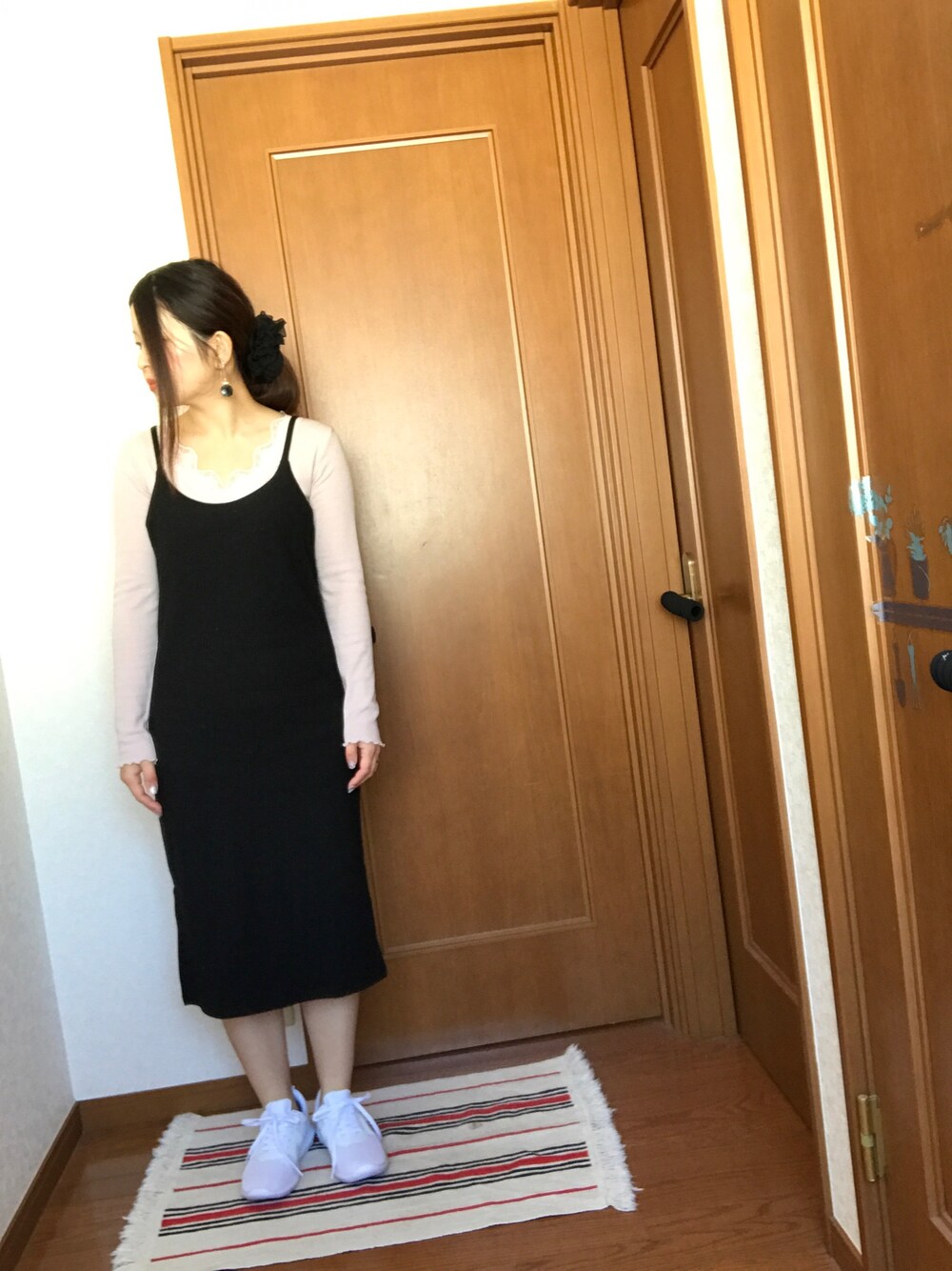 ブラック系のワンピース/ドレス、ホワイト系のスニーカー、ピンク系のTシャツ/カットソーを着用したレディースの春コーディネートの1枚目の写真