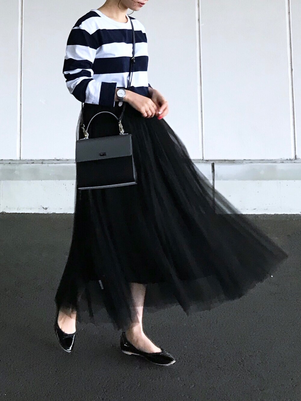ブラック系のハンドバッグ、ブルー系のTシャツ/カットソー、ブラック系のバレエシューズを着用したレディースの春コーディネートの1枚目の写真