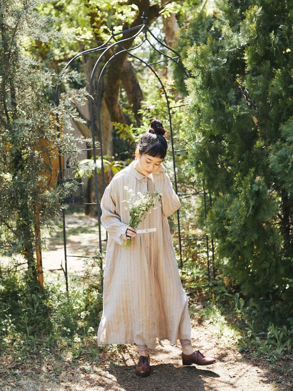 ベージュ系のシャツワンピース、ブラウン系のドレスシューズを着用したレディースの春コーディネートの1枚目の写真