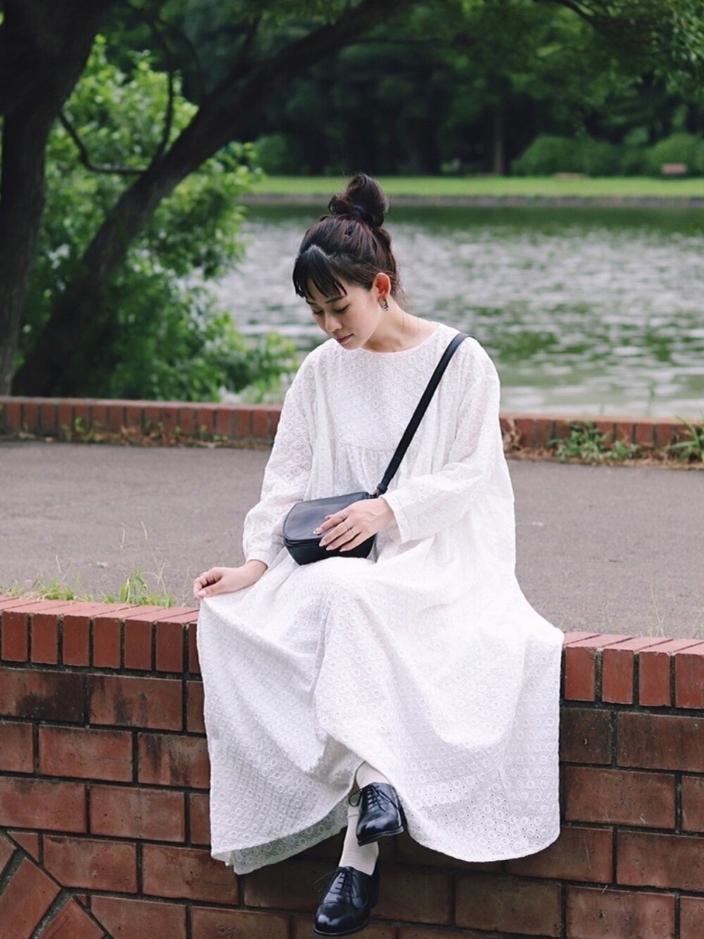 ブラック系のバッグ、ホワイト系のワンピース、ブラック系のドレスシューズを着用したレディースの秋コーディネートの1枚目の写真