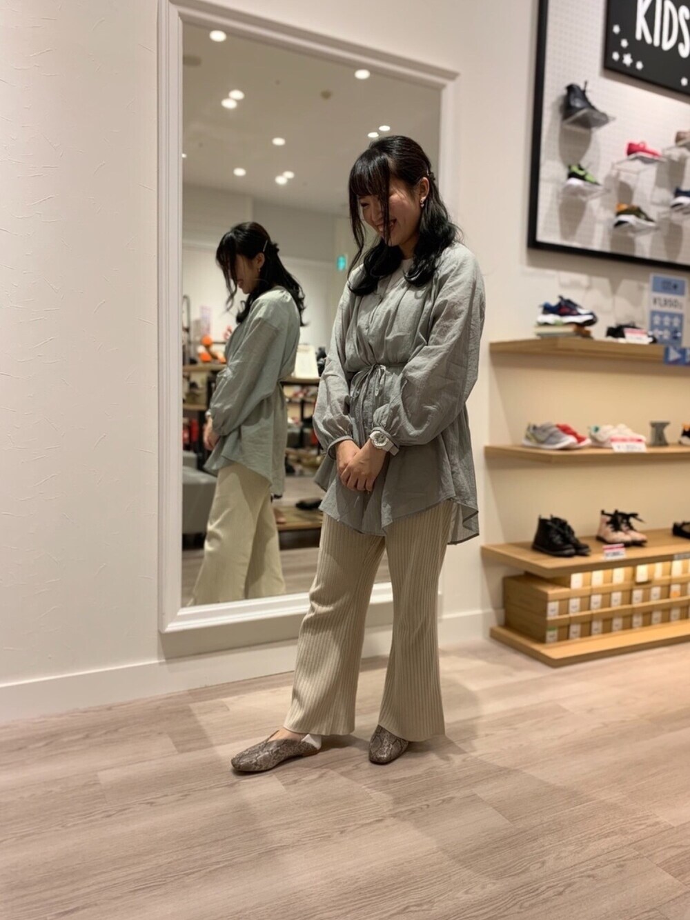 グリーン系のシャツ/ブラウス、グレー系のパンプスを着用したレディースの春コーディネートの1枚目の写真