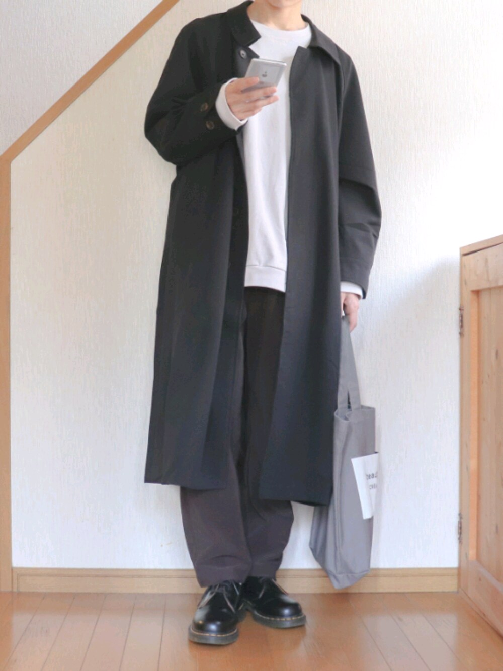 ブラック系のステンカラーコート、グレー系のTシャツ/カットソー、パープル系のその他パンツを着用したメンズの秋コーディネートの1枚目の写真