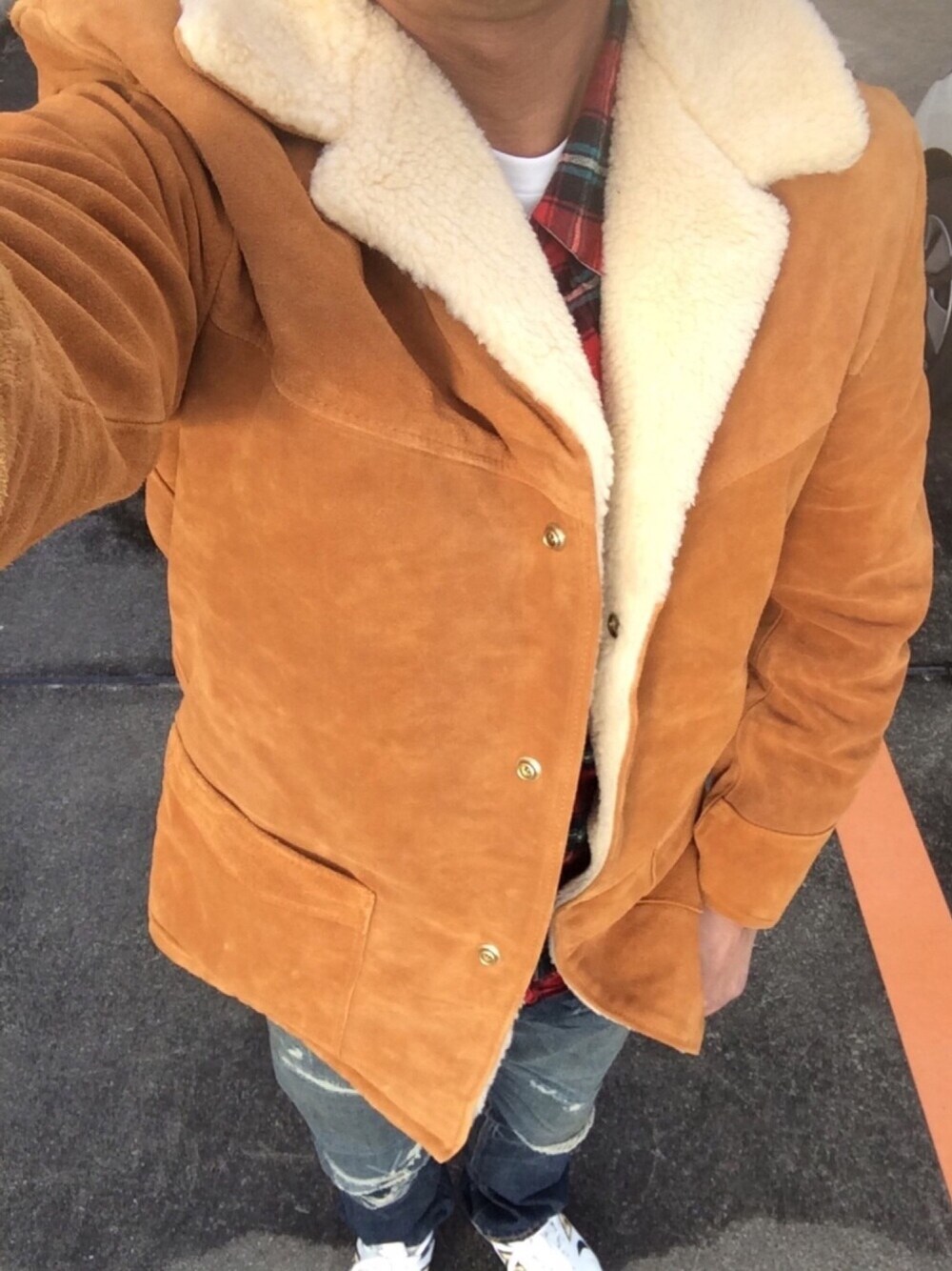 ブラウン系のムートンコート、ブルー系のデニムパンツ、レッド系のシャツ/ブラウスを着用したメンズの冬コーディネートの1枚目の写真