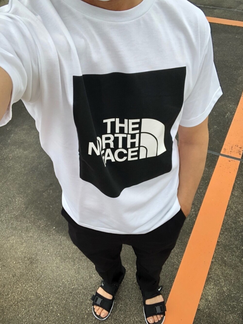 ホワイト系のTシャツ/カットソー、ブラック系のその他パンツ、ブラック系のサンダルを着用したメンズの夏コーディネートの1枚目の写真
