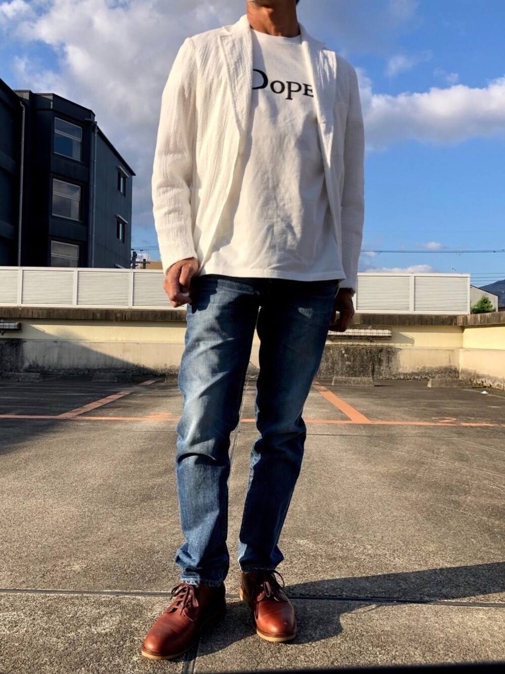 ホワイト系のテーラードジャケット、ホワイト系のTシャツ/カットソー、ブルー系のデニムパンツを着用したメンズの春コーディネートの1枚目の写真