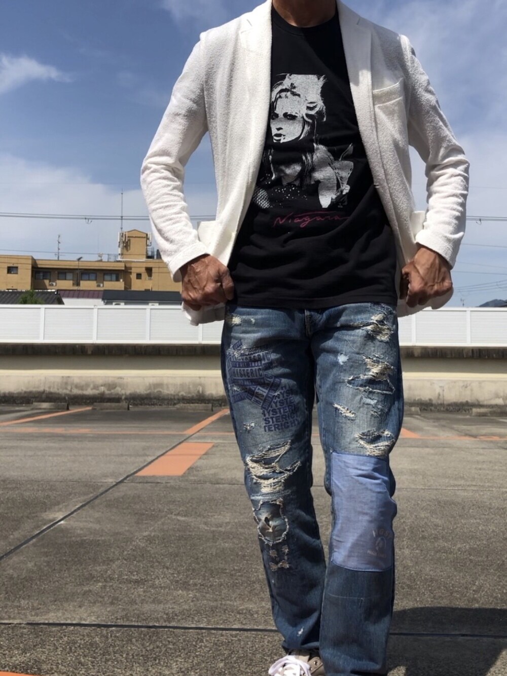 ホワイト系のテーラードジャケット、ブルー系のデニムパンツ、ブラック系のTシャツ/カットソーを着用したメンズの春コーディネートの1枚目の写真