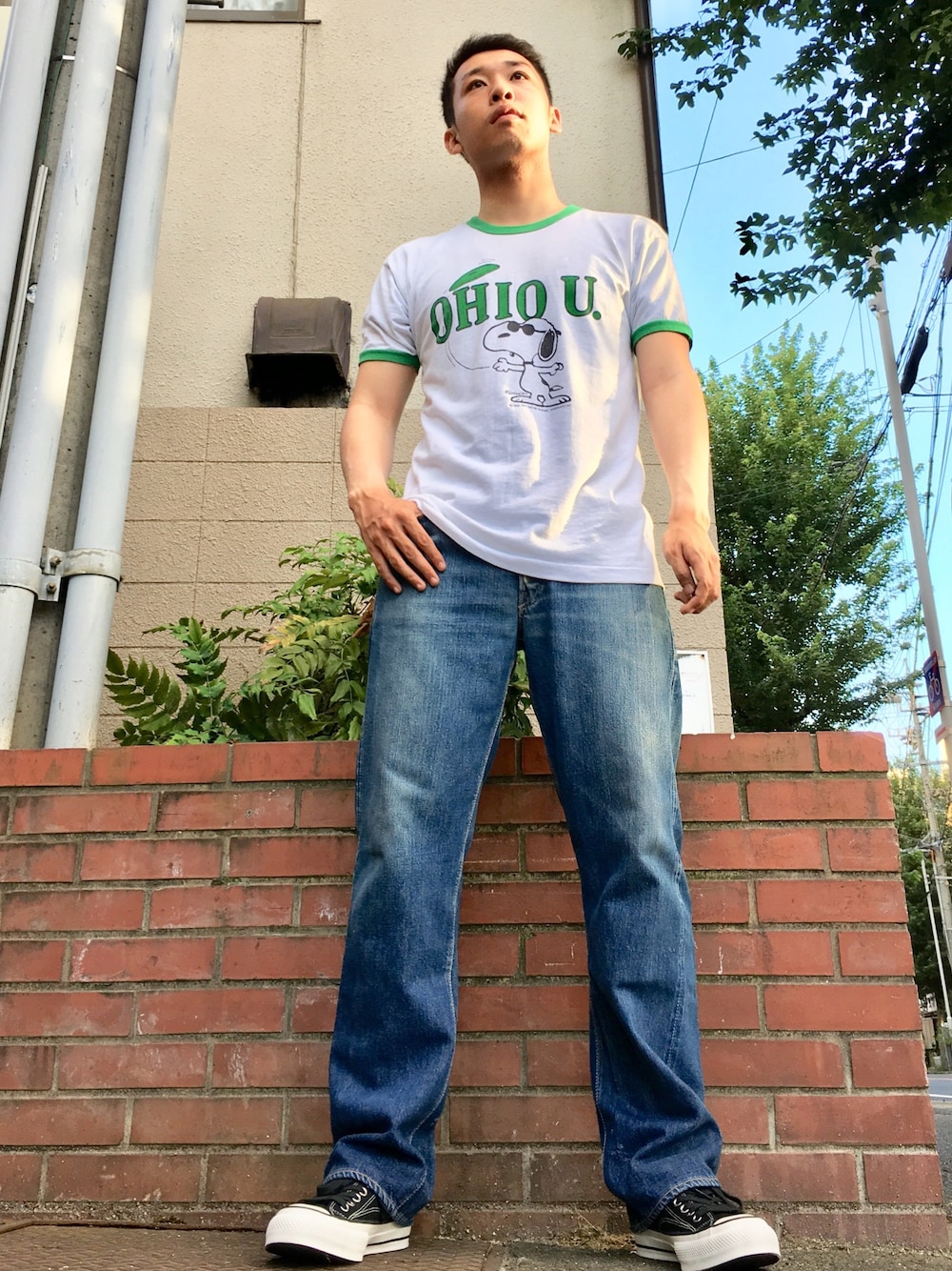 ホワイト系のTシャツ/カットソー、ブルー系のデニムパンツ、ブラック系のスニーカーを着用したメンズの夏コーディネートの1枚目の写真