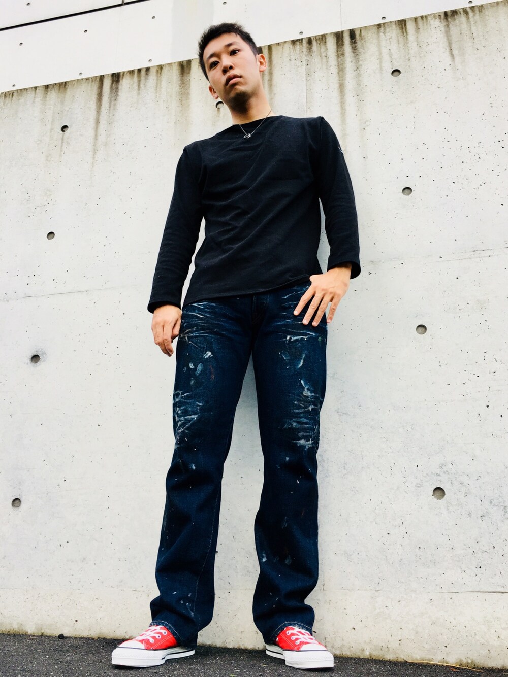 ブラック系のTシャツ/カットソー、ブルー系のデニムパンツ、レッド系のスニーカーを着用したメンズの秋コーディネートの1枚目の写真