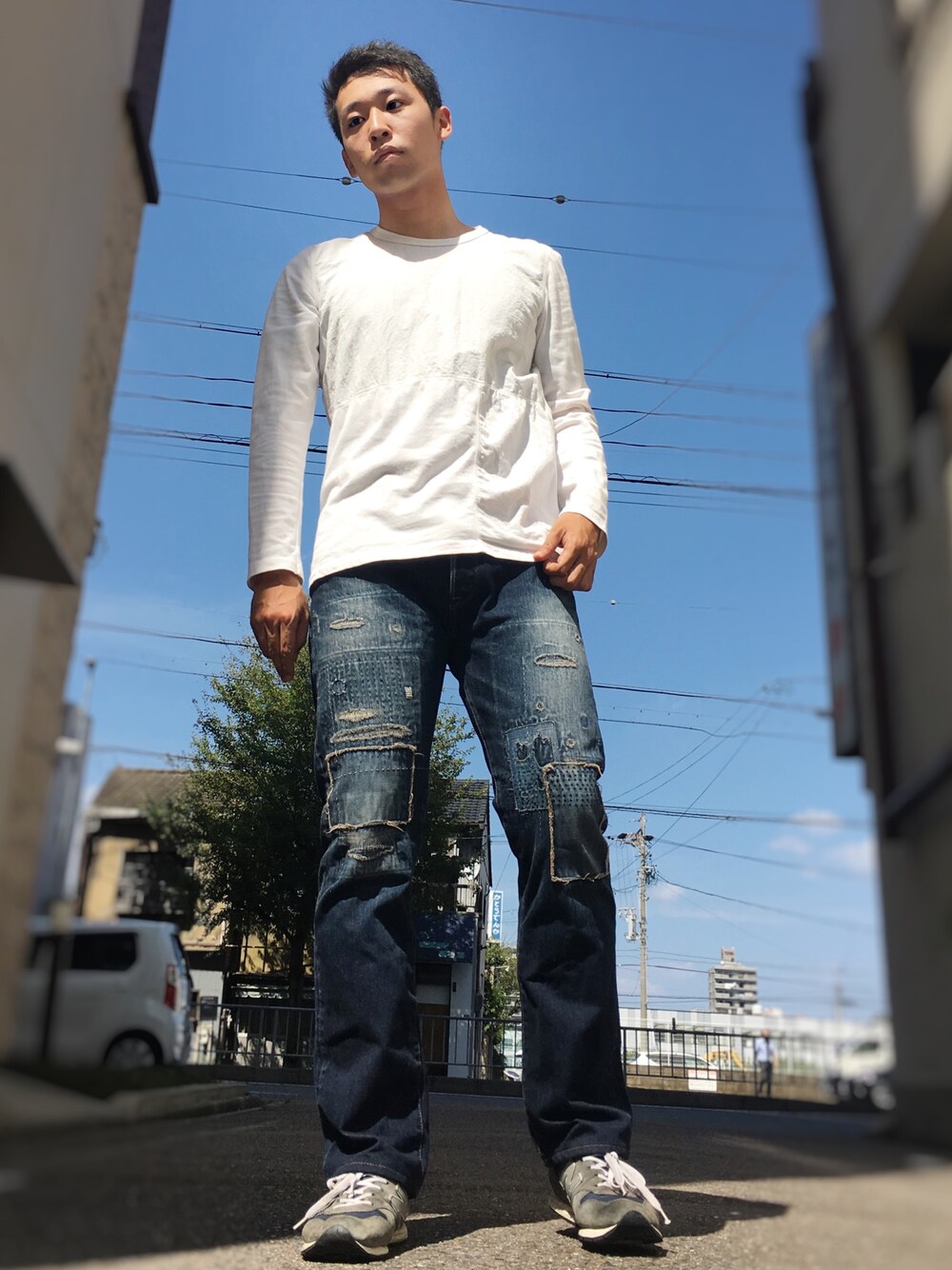 ホワイト系のTシャツ/カットソー、ブルー系のデニムパンツ、ブルー系のスニーカーを着用したメンズの秋コーディネートの1枚目の写真