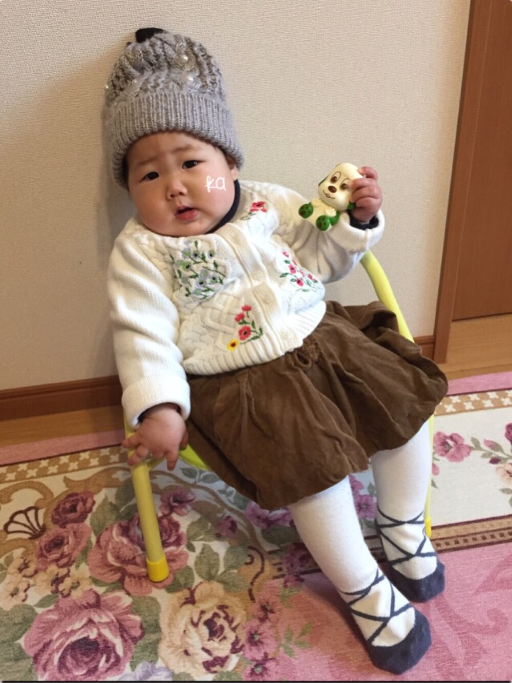 ホワイト系のカーディガン/ボレロ、ブラウン系のスカート、グレー系のニットキャップ/ビーニーを着用したキッズの冬コーディネートの1枚目の写真