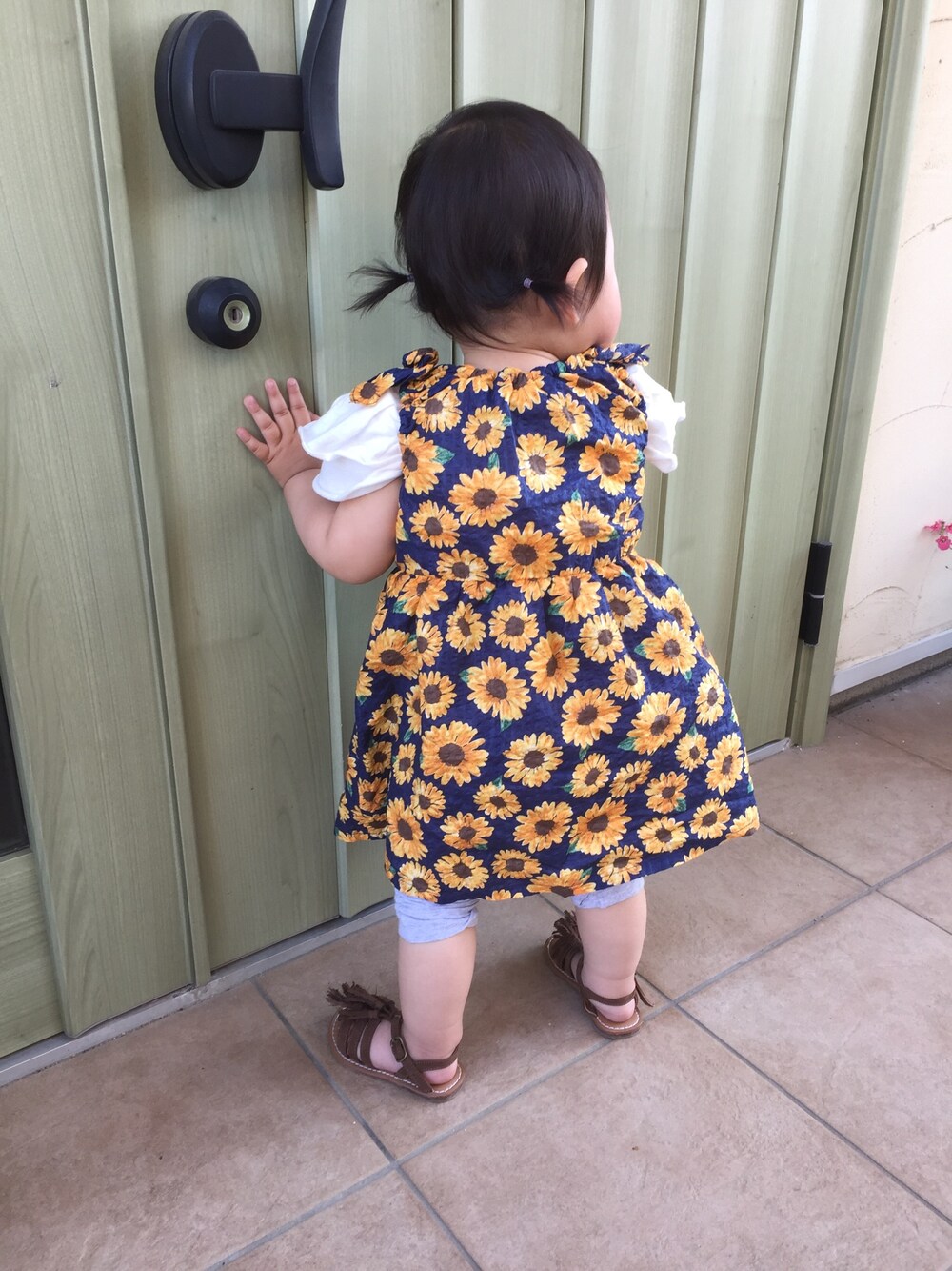 ブルー系のワンピース、ホワイト系のTシャツ/カットソー、ブラウン系のサンダルを着用したキッズの春コーディネートの1枚目の写真
