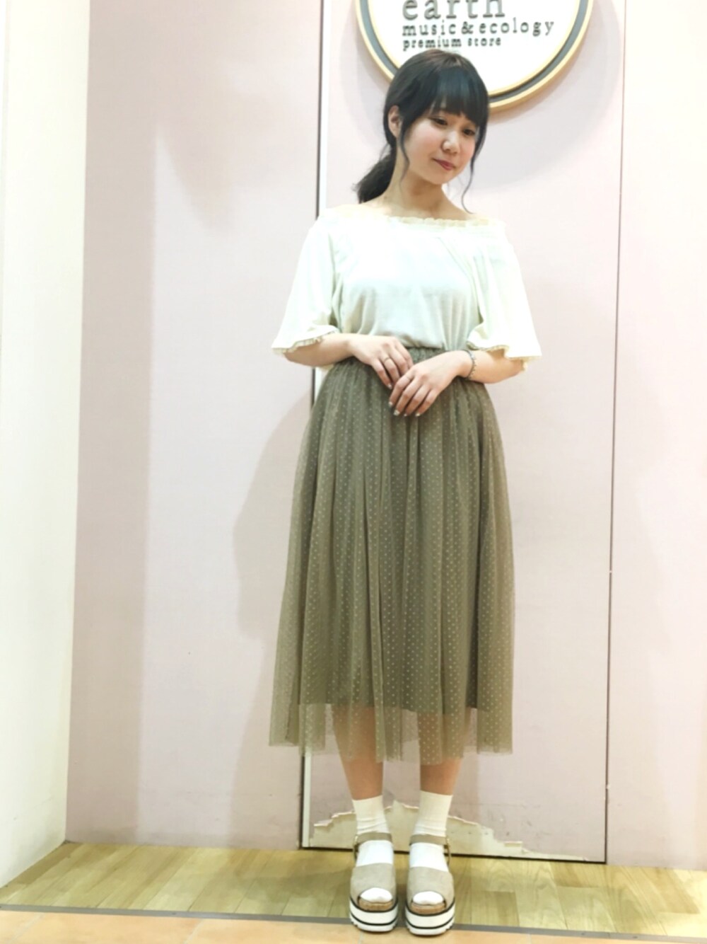 ベージュ系のスカート、ホワイト系のTシャツ/カットソーを着用したレディースの夏コーディネートの1枚目の写真