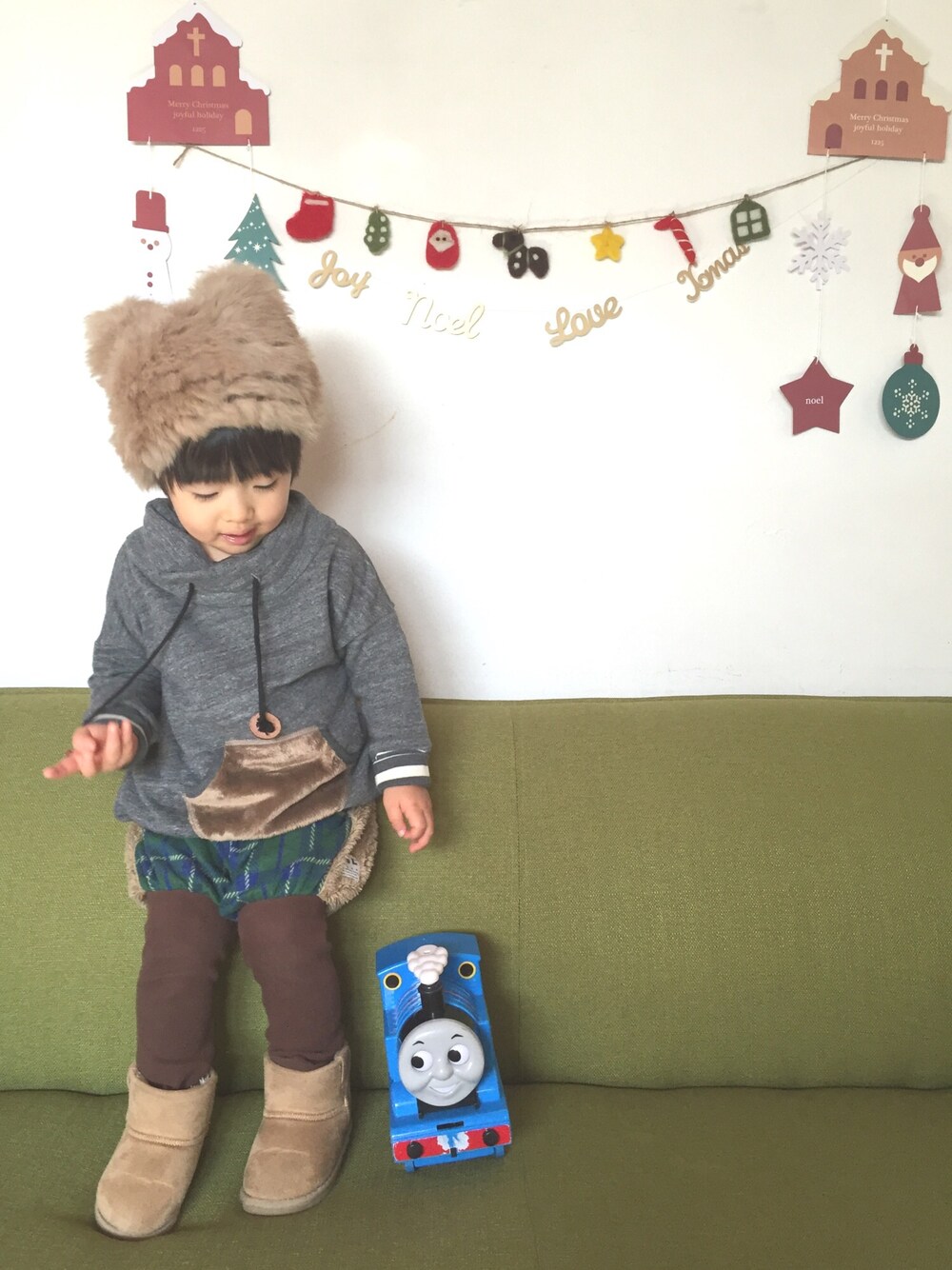 グレー系のスウェット、グリーン系のその他パンツ、ベージュ系の帽子を着用したキッズの冬コーディネートの1枚目の写真