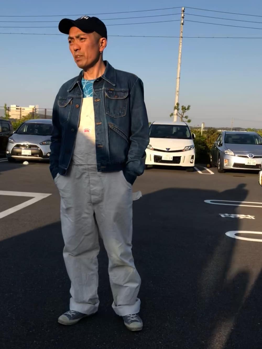 「肌ウーノ、古着MIX、PR、オーバーオール、白オーバーオール、デニムジャケット、古着、キャップ、ヘルメット、原付きスタイル」｜「maverickの古着（デニムジャケット、ブルー系）」を使った、香月ダイスケさん（メンズ・166cm）の春コーディネートの1枚目の写真