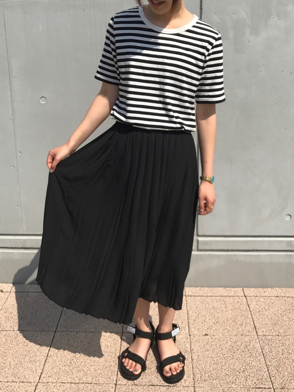 ホワイト系のTシャツ/カットソー、ブラック系のスカート、ブラック系のサンダルを着用したレディースの春コーディネートの1枚目の写真