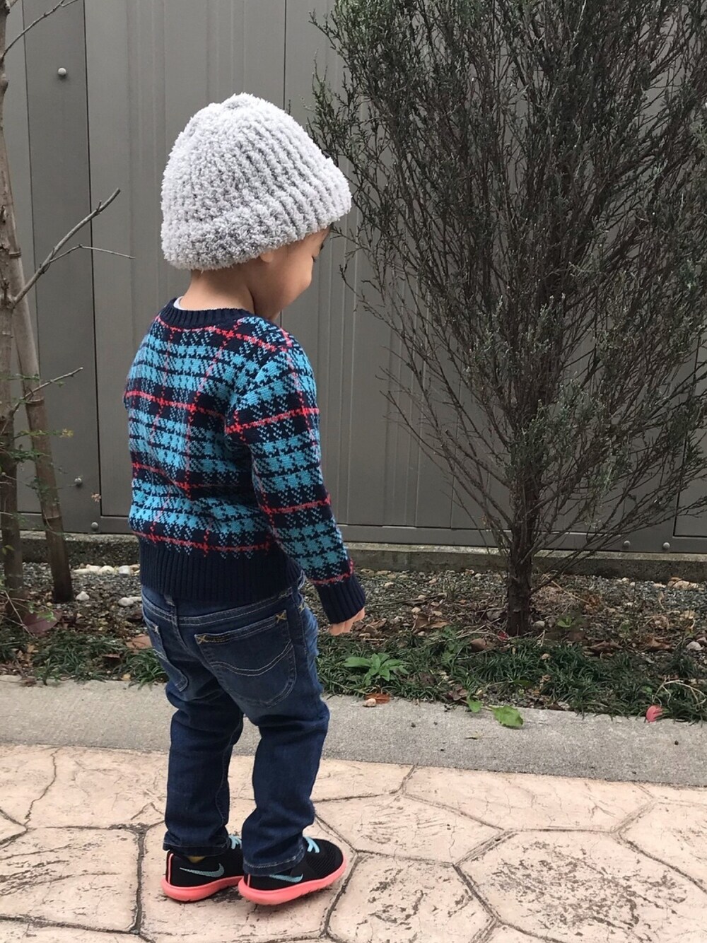 ブルー系のニット/セーター、ブルー系のデニムパンツ、ブラック系のスニーカーを着用したキッズの冬コーディネートの1枚目の写真