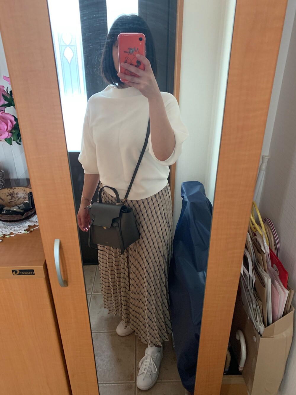 ホワイト系のニット/セーター、その他のスカート、グレー系のショルダーバッグを着用したレディースの春コーディネートの1枚目の写真