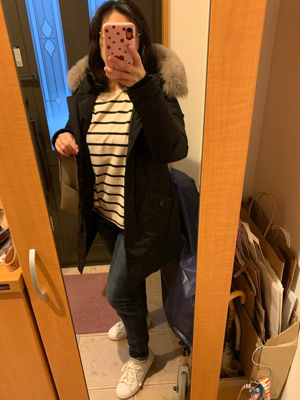 ブラック系のダウンジャケット/コート、ブラック系のTシャツ/カットソー、ブルー系のデニムパンツを着用したレディースの冬コーディネートの1枚目の写真