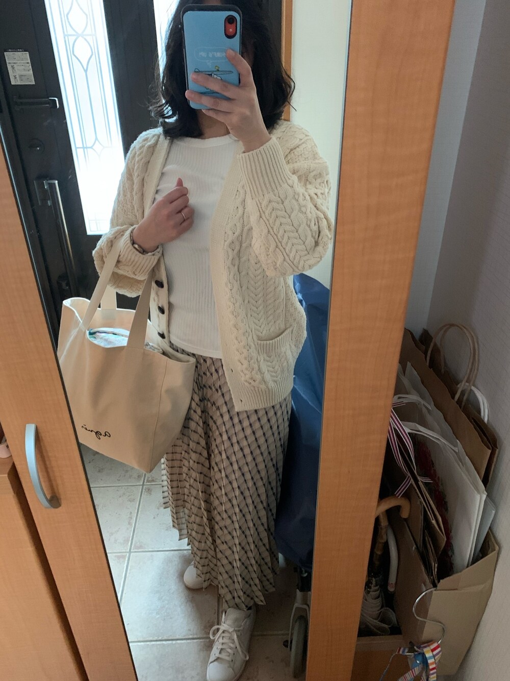 ホワイト系のカーディガン/ボレロ、その他のスカート、ホワイト系のスニーカーを着用したレディースの春コーディネートの1枚目の写真