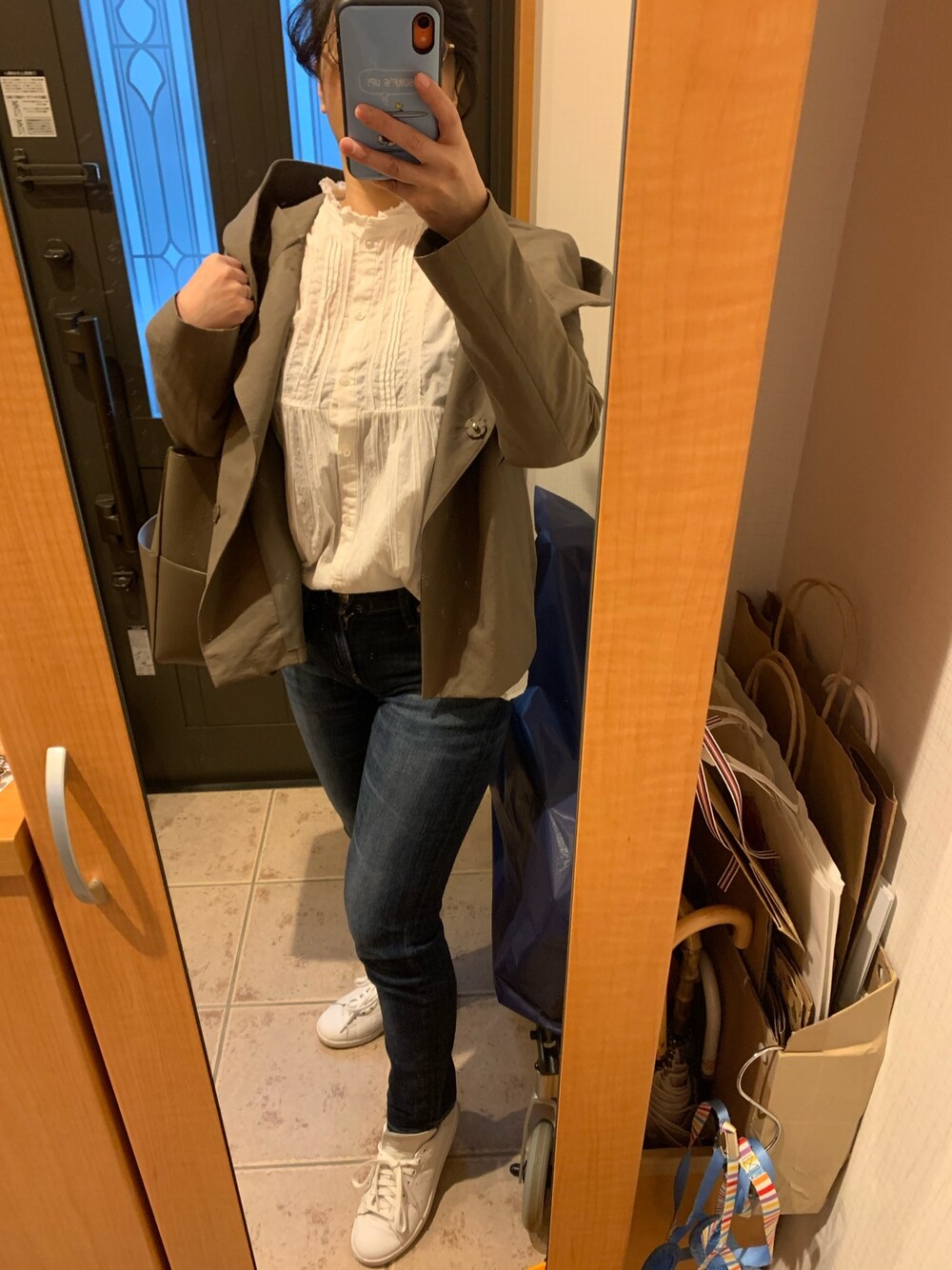 グレー系のブルゾン、ホワイト系のシャツ/ブラウス、ブルー系のデニムパンツを着用したレディースの春コーディネートの1枚目の写真