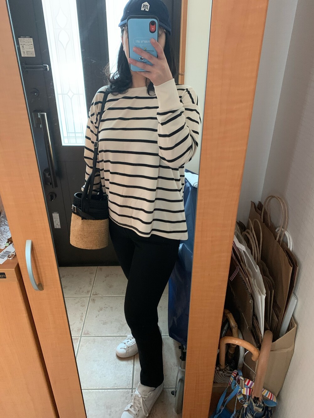 ブラック系のTシャツ/カットソー、ブラック系のデニムパンツ、ホワイト系のスニーカーを着用したレディースの春コーディネートの1枚目の写真