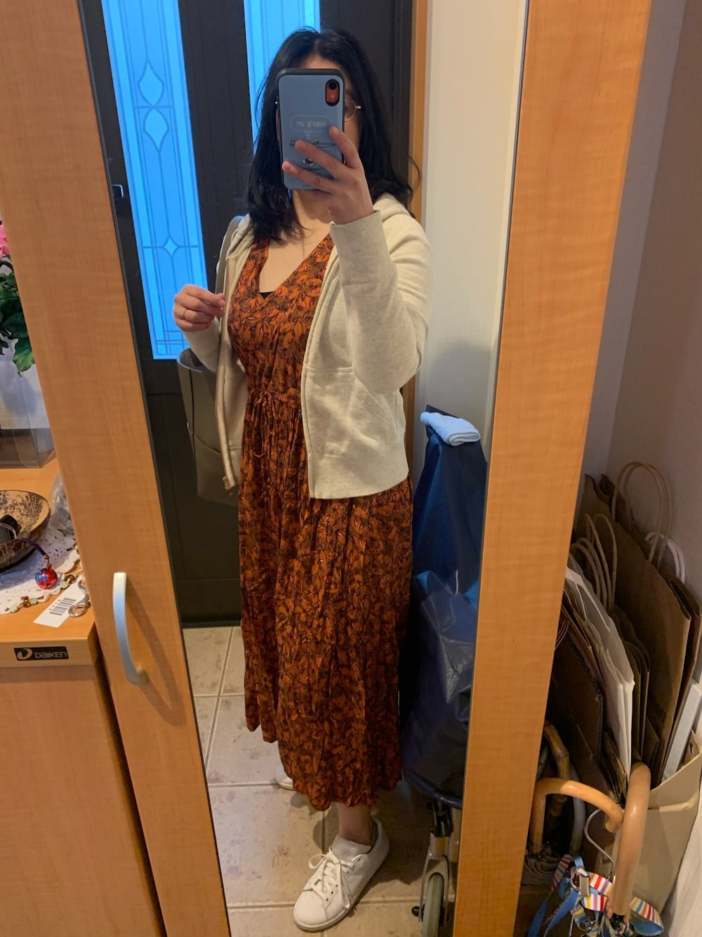 ベージュ系のパーカー、ブラウン系のワンピース/ドレス、ホワイト系のスニーカーを着用したレディースの春コーディネートの1枚目の写真