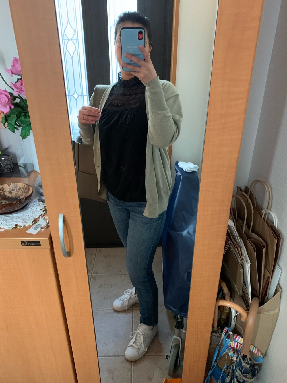 グレー系のカーディガン/ボレロ、ブラック系のシャツ/ブラウス、ブルー系のデニムパンツを着用したレディースの春コーディネートの1枚目の写真