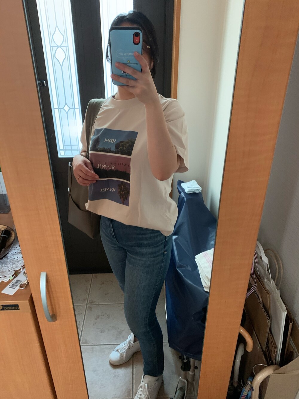 ベージュ系のTシャツ/カットソー、ブルー系のデニムパンツ、ホワイト系のスニーカーを着用したレディースの夏コーディネートの1枚目の写真